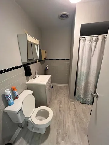 a white toilet sitting next to a bathroom sink and a mirror