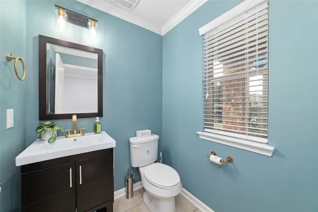 a bathroom with a toilet a sink a mirror and a window