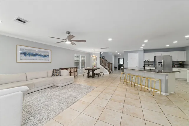 a living room with fireplace furniture and a view of kitchen