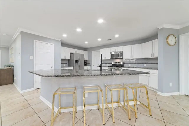 a kitchen with stainless steel appliances granite countertop a stove a sink a microwave and a refrigerator