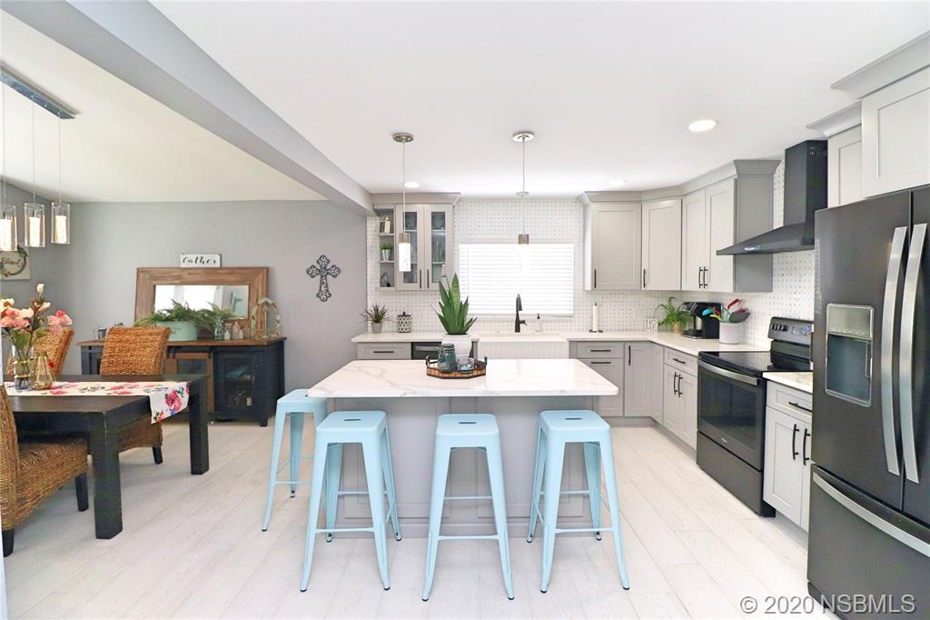 129 Rhode Island Street Edgewater, FL 32132 - Photo 13 of 49 a kitchen with refrigerator cabinets dining table and chairs