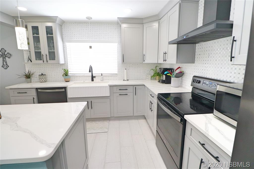 129 Rhode Island Street Edgewater, FL 32132 - Photo 14 of 49 a kitchen with a sink a stove and cabinets