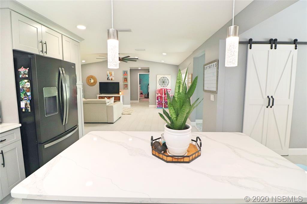 129 Rhode Island Street Edgewater, FL 32132 - Photo 16 of 49 a kitchen with refrigerator and microwave
