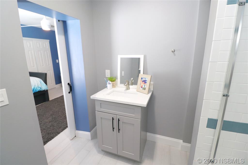 129 Rhode Island Street Edgewater, FL 32132 - Photo 21 of 49 a bathroom with a sink a mirror and a toilet