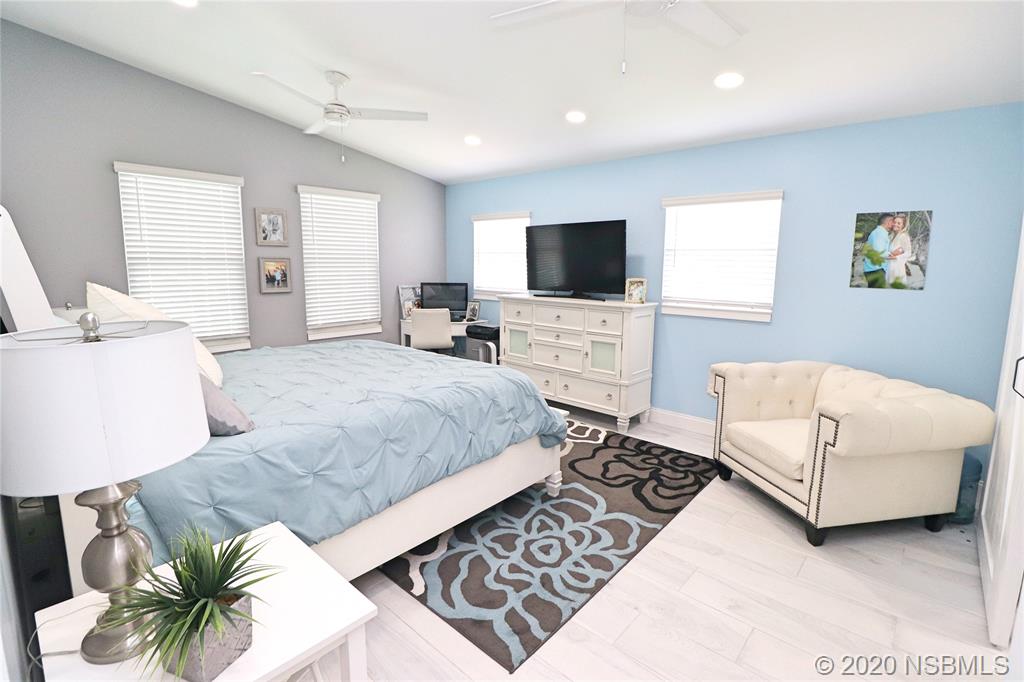 129 Rhode Island Street Edgewater, FL 32132 - Photo 25 of 49 a bedroom with a bed a couch and a flat screen television
