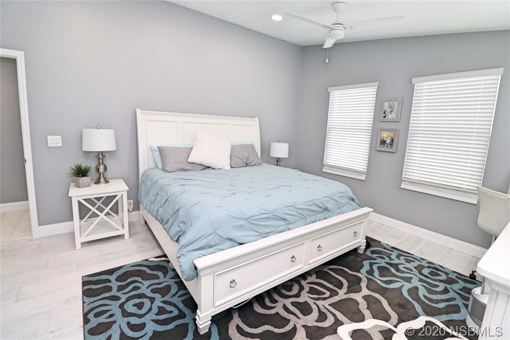 129 Rhode Island Street Edgewater, FL 32132 - Photo 26 of 49 a bedroom with a bed and a lamp on dresser
