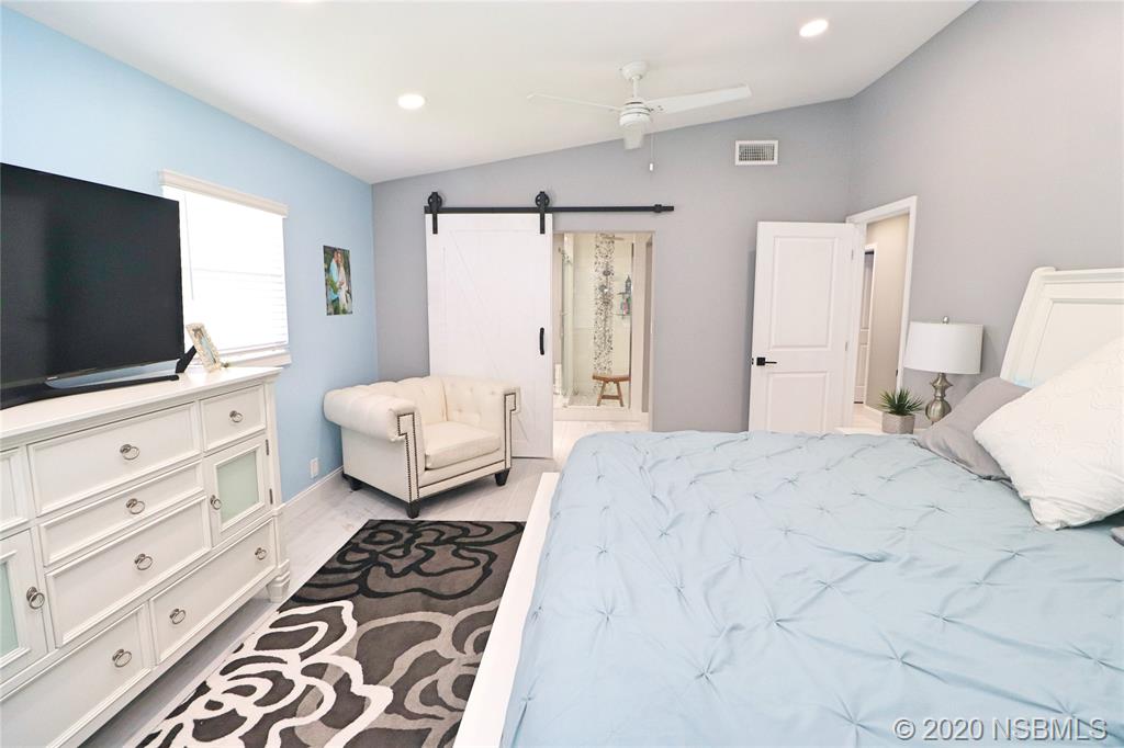129 Rhode Island Street Edgewater, FL 32132 - Photo 27 of 49 a bedroom with a bed and flat screen tv