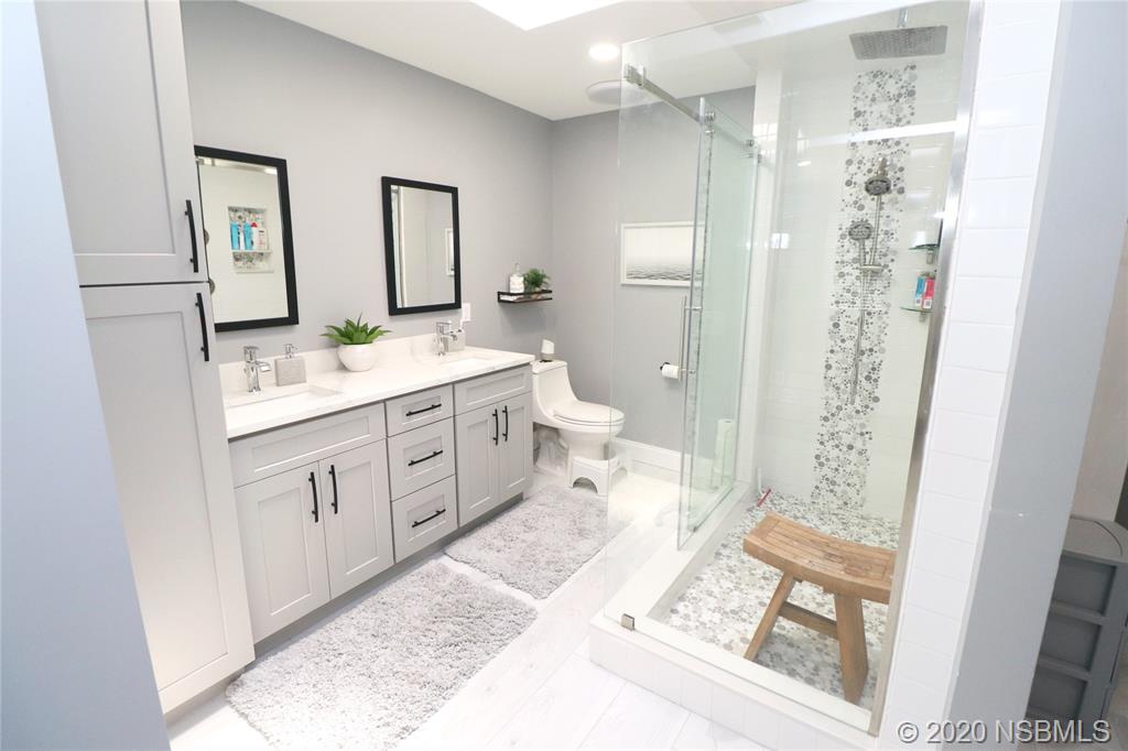 129 Rhode Island Street Edgewater, FL 32132 - Photo 28 of 49 a spacious bathroom with a double vanity sink a toilet a shower and a mirror
