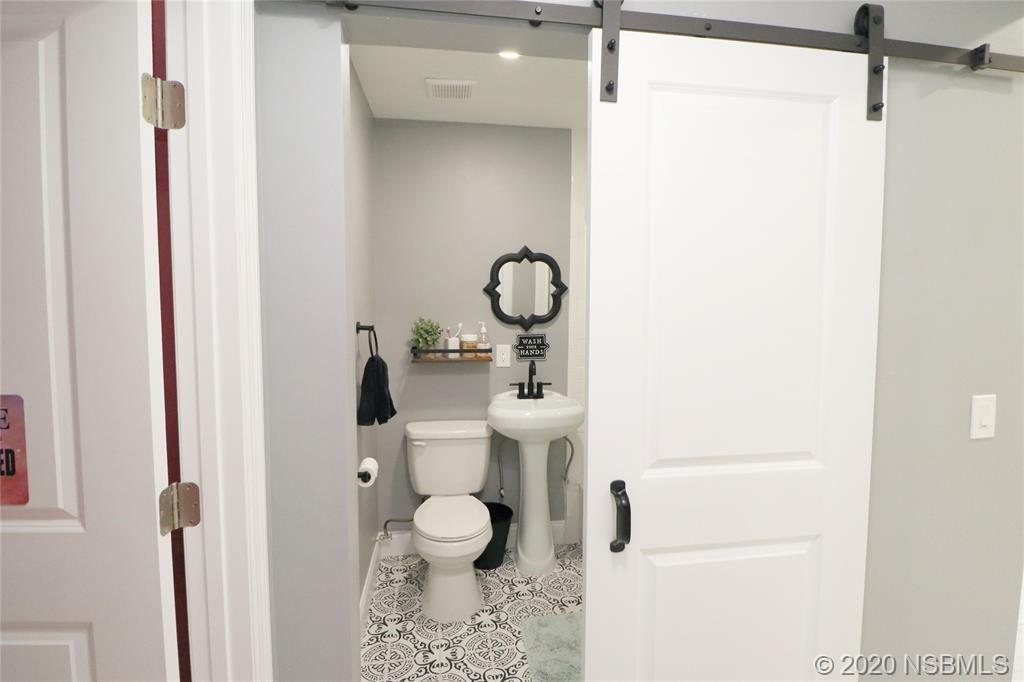 129 Rhode Island Street Edgewater, FL 32132 - Photo 34 of 49 a bathroom with a toilet a sink and a mirror