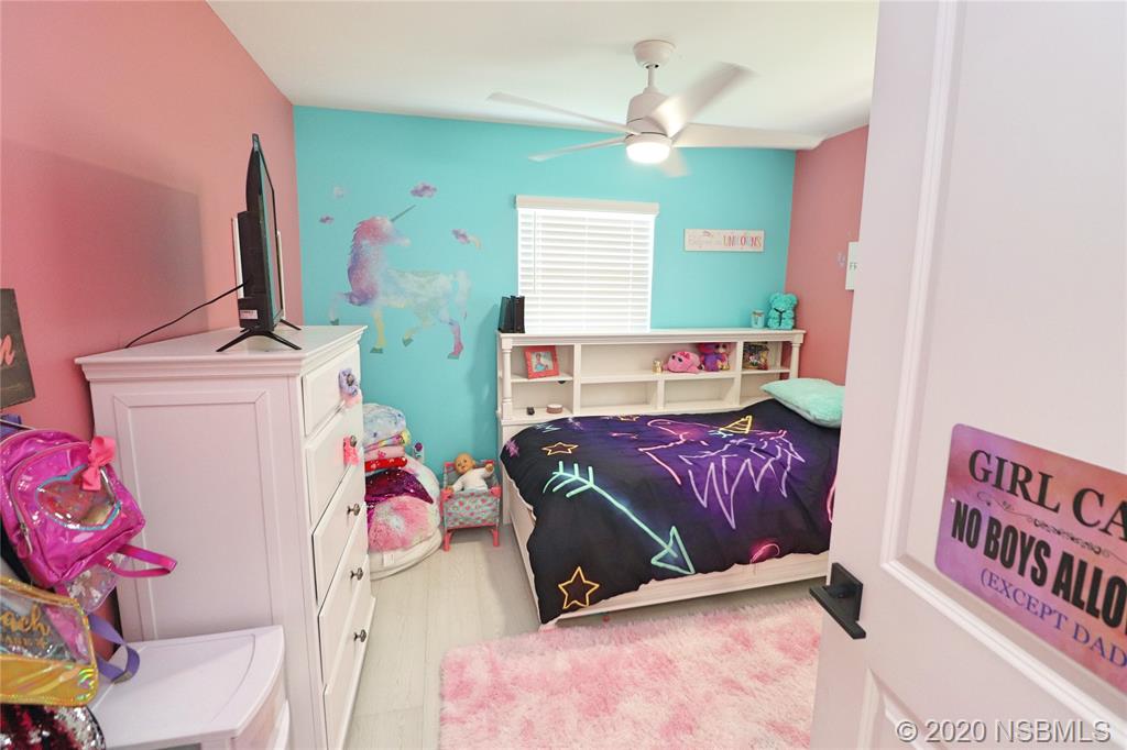 129 Rhode Island Street Edgewater, FL 32132 - Photo 36 of 49 a bedroom with a bed and a chandelier