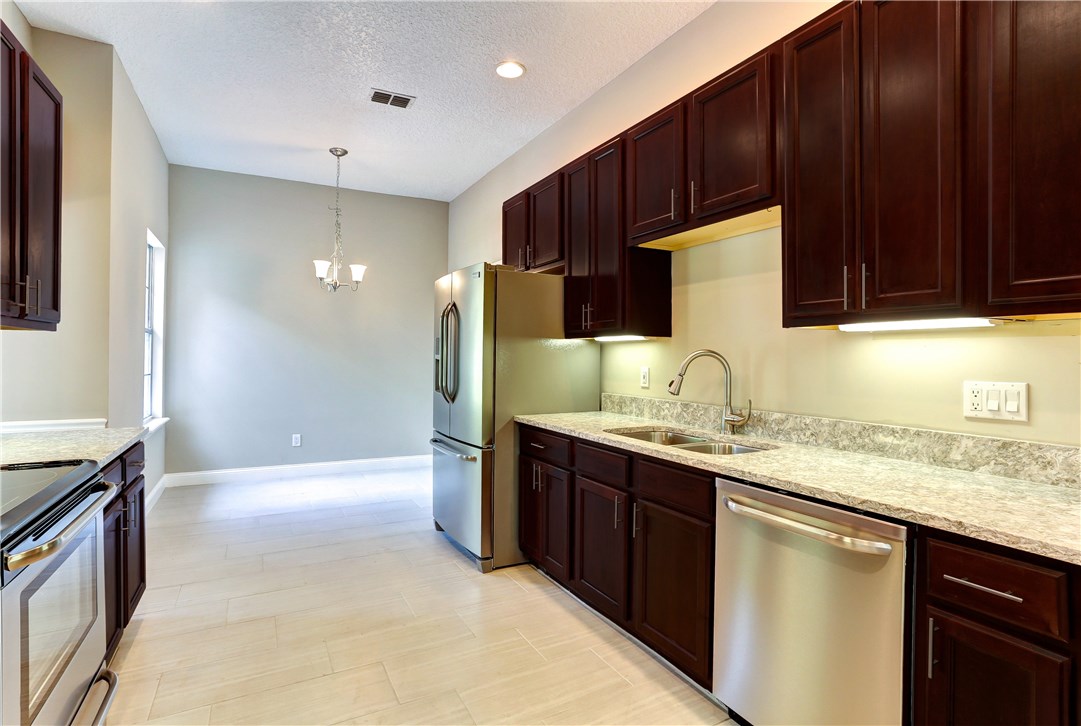 96921 Blackrock Road Yulee, FL 32097 - Photo 14 of 34 a kitchen with kitchen island granite countertop wooden cabinets a sink and a stove