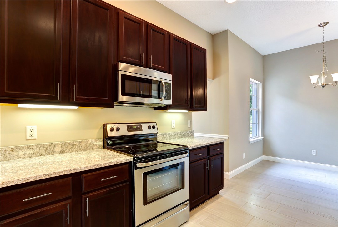 96921 Blackrock Road Yulee, FL 32097 - Photo 16 of 34 a kitchen with granite countertop wooden cabinets and stainless steel appliances
