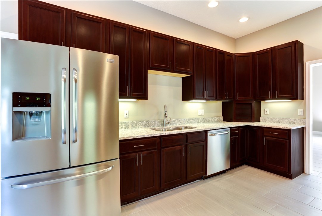 96921 Blackrock Road Yulee, FL 32097 - Photo 3 of 34 a kitchen with granite countertop a refrigerator and a sink