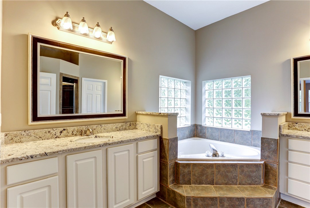 96921 Blackrock Road Yulee, FL 32097 - Photo 7 of 34 a spacious bathroom with sinks granite countertop tub and a mirror