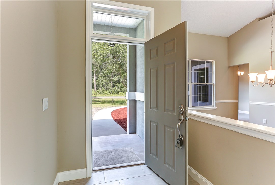 96921 Blackrock Road Yulee, FL 32097 - Photo 9 of 34 a view of a room that has a large window and wooden floor