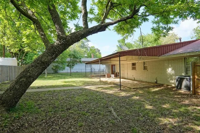 a view of a house with backyard and sitting area
