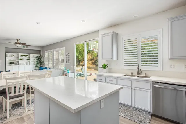 a large kitchen with kitchen island a sink and a large window