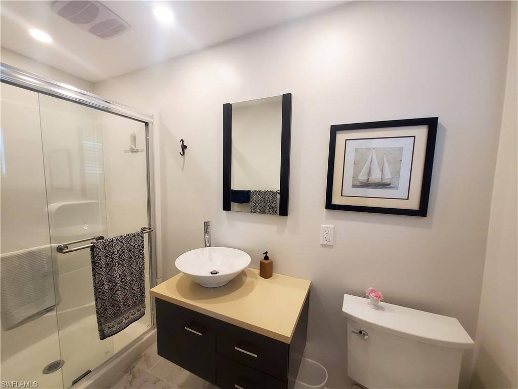 7 Topaz Lane, Unit T7 Naples, FL 34112 - Photo 19 of 23 a bathroom with a granite countertop sink mirror vanity and toilet