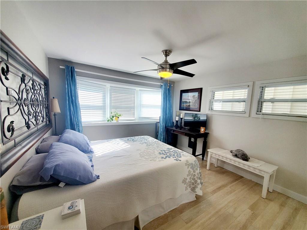 7 Topaz Lane, Unit T7 Naples, FL 34112 - Photo 20 of 23 a bedroom with a bed and a chandelier