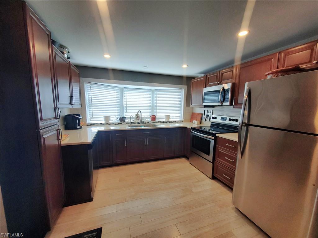 7 Topaz Lane, Unit T7 Naples, FL 34112 - Photo 2 of 23 a kitchen with granite countertop stainless steel appliances a refrigerator and a sink