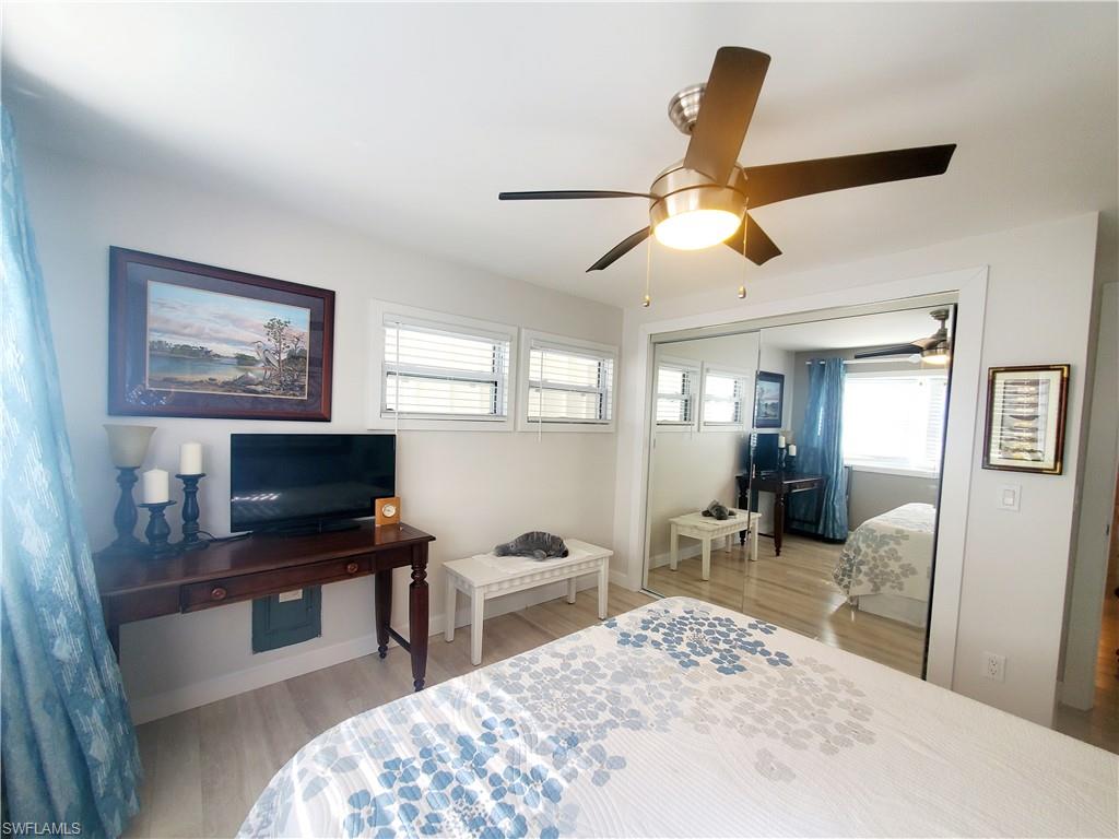 7 Topaz Lane, Unit T7 Naples, FL 34112 - Photo 21 of 23 a bedroom with a bed and a chandelier