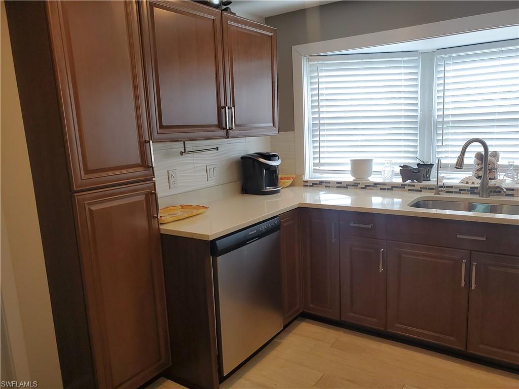 7 Topaz Lane, Unit T7 Naples, FL 34112 - Photo 4 of 23 a kitchen with stainless steel appliances granite countertop a sink dishwasher a refrigerator and cabinets with wooden floor