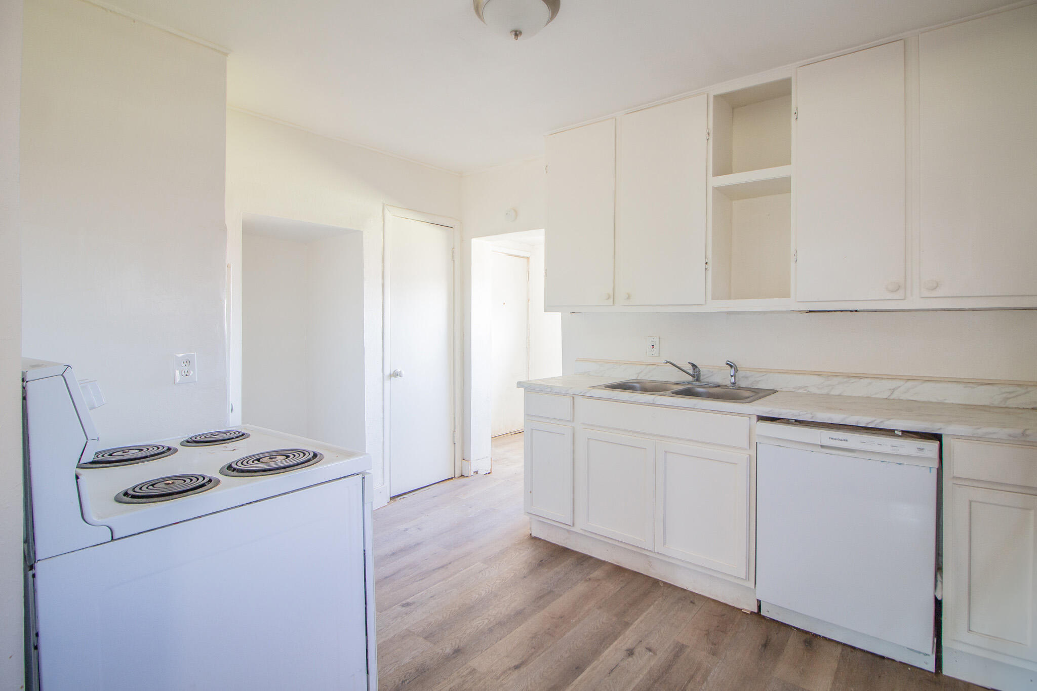 315 South 13th Street Slaton, TX 79364 - Photo 6 of 14 a kitchen with a sink a stove and white cabinets