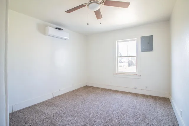 an empty room with a window and a ceiling fan