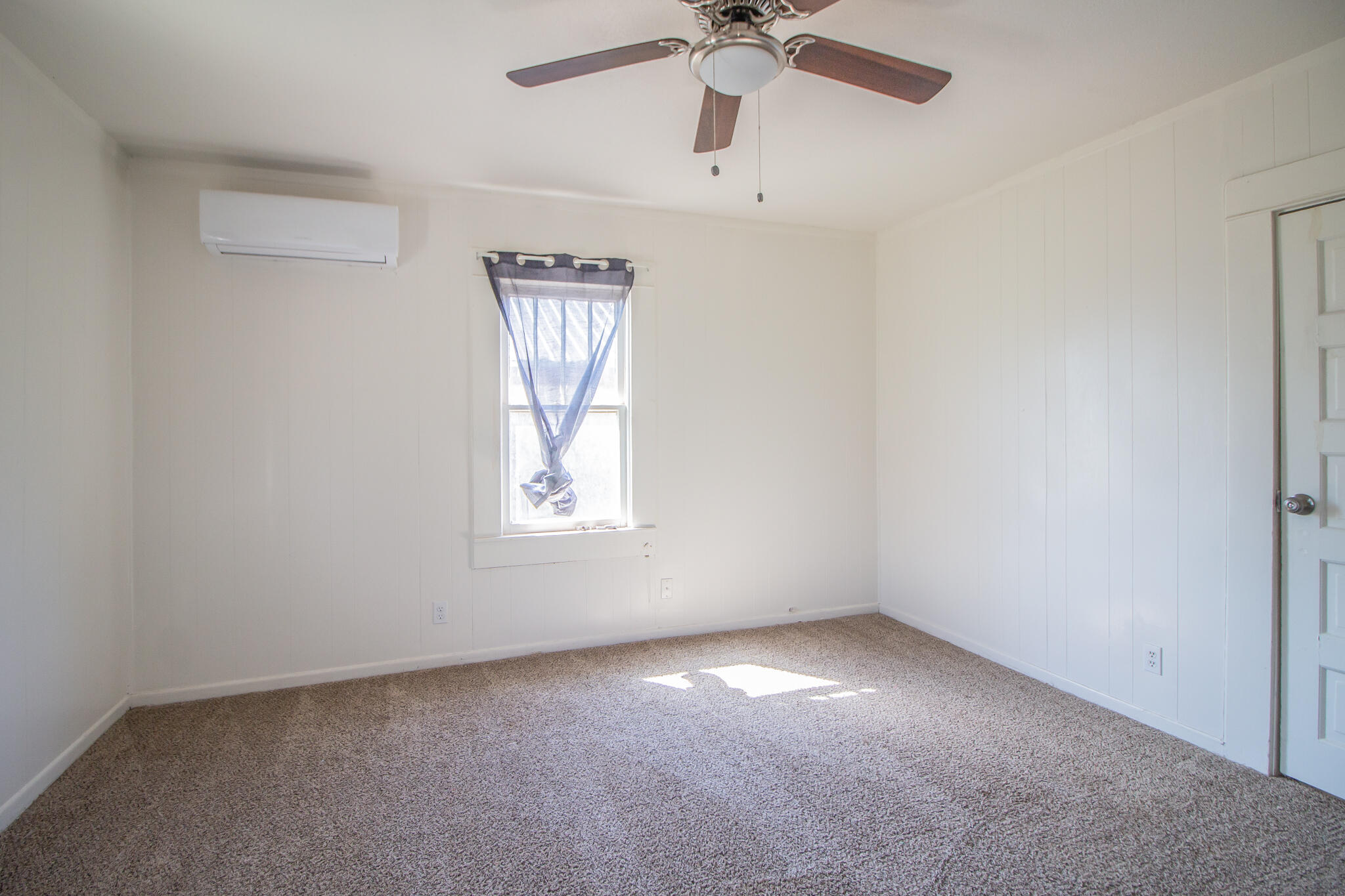 315 South 13th Street Slaton, TX 79364 - Photo 10 of 14 an empty room with a window and a fan