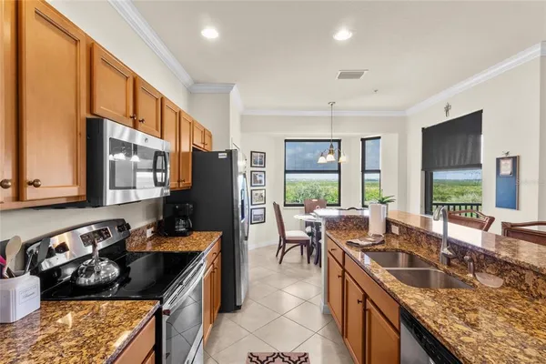 a kitchen with stainless steel appliances granite countertop a stove a refrigerator and a microwave