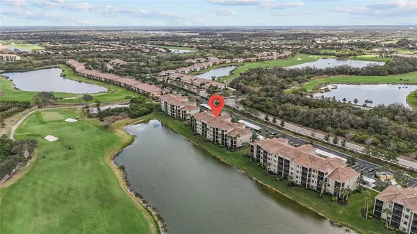 an aerial view of residential houses with outdoor space and lake view