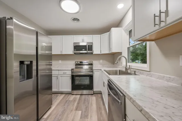 a kitchen with granite countertop a sink and cabinets