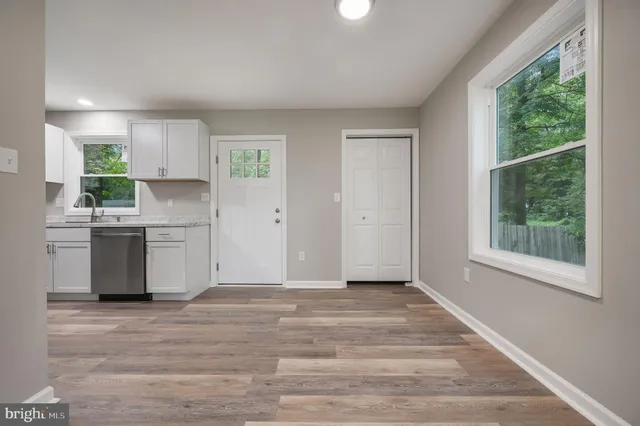 an empty room with wooden floor and windows