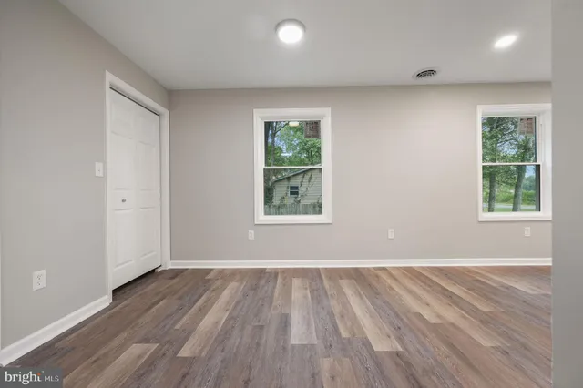 an open kitchen with kitchen island wooden floors and stainless steel appliances