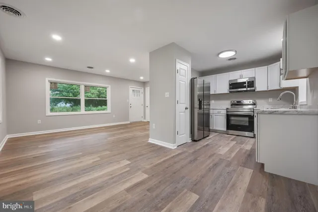 a kitchen with kitchen island granite countertop a stove sink and refrigerator