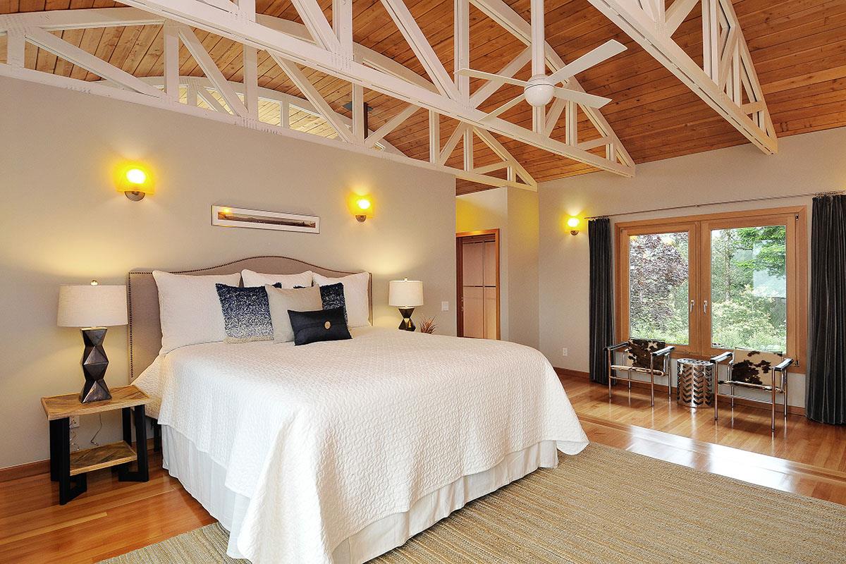 214 Swett Road Woodside, CA 94062 - Photo 21 of 67 a large bedroom with a bed and wooden floor
