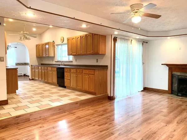 a large kitchen with granite countertop a stove cabinets and wooden floor