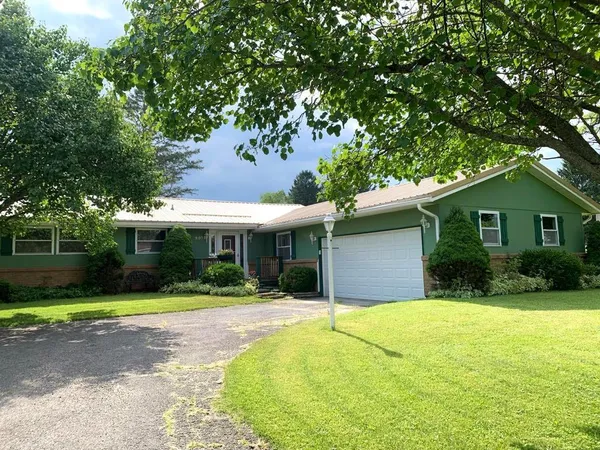 a front view of a house with yard and green space