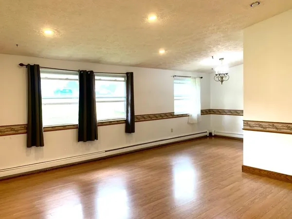a view of a livingroom with wooden floor and a window
