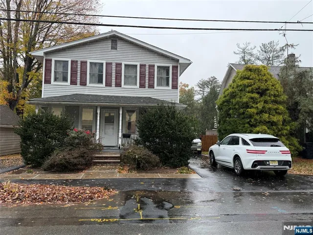 a white car parked in front of a house