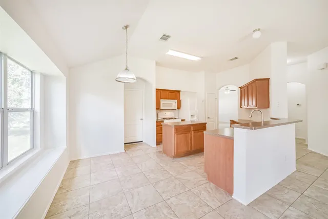 a view of kitchen with stainless steel appliances granite countertop cabinets and window