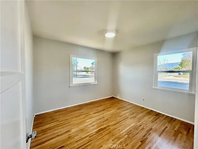 a view of a room with wooden floor and window