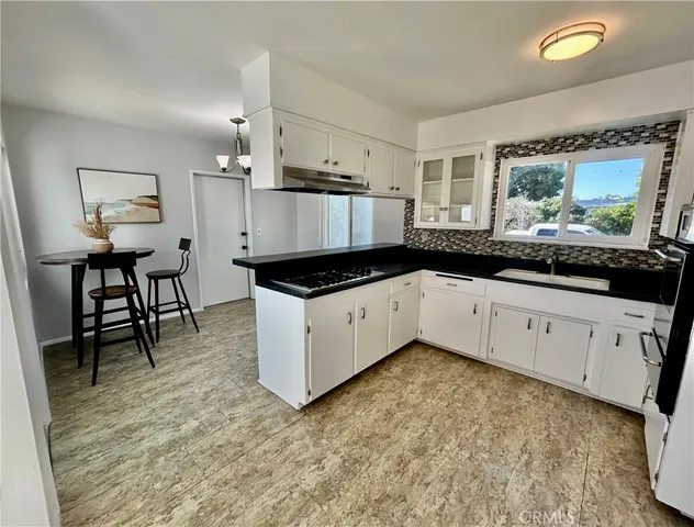 a kitchen with granite countertop white cabinets and white appliances