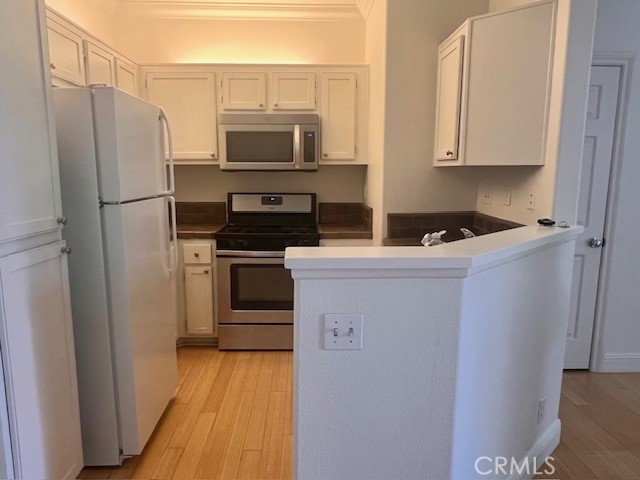 511 Birch Grove Irvine, CA 92618 - Photo 10 of 15 a kitchen with a refrigerator sink and microwave