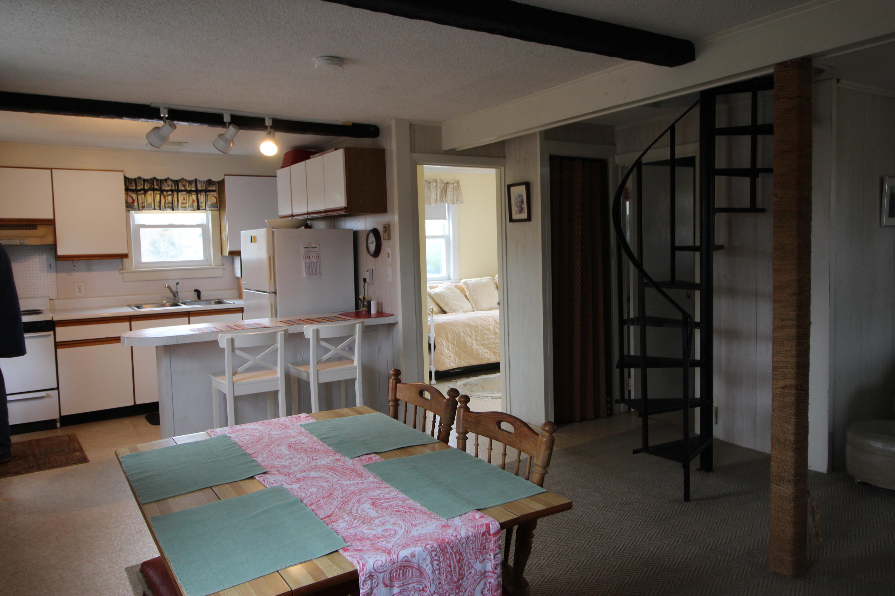 21 Knowles Heights Road Truro, MA 02666 - Photo 17 of 38 a kitchen with a table chairs refrigerator and cabinets
