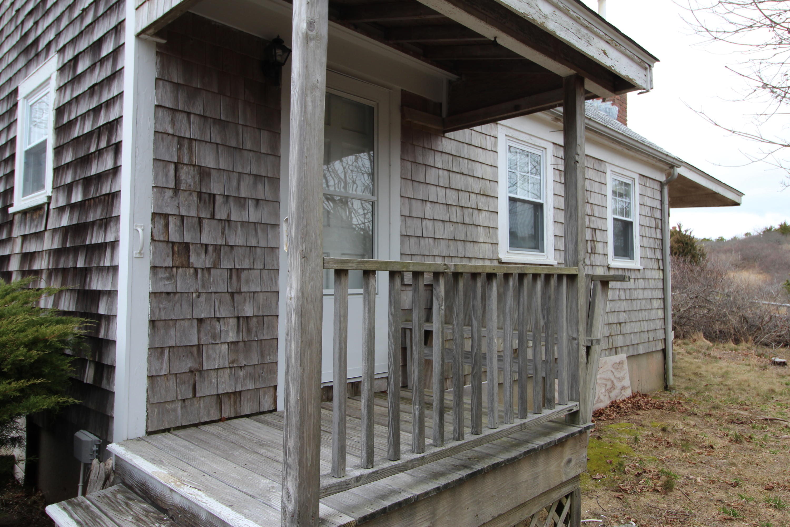 21 Knowles Heights Road Truro, MA 02666 - Photo 10 of 38 a view of a house with a small yard and wooden fence and large trees