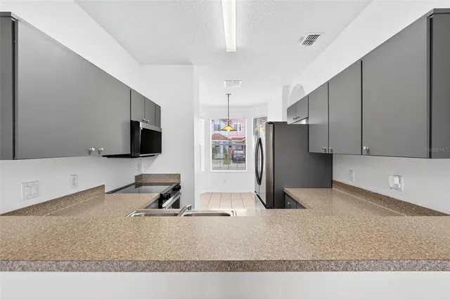 a kitchen with stainless steel appliances granite countertop a refrigerator and a sink