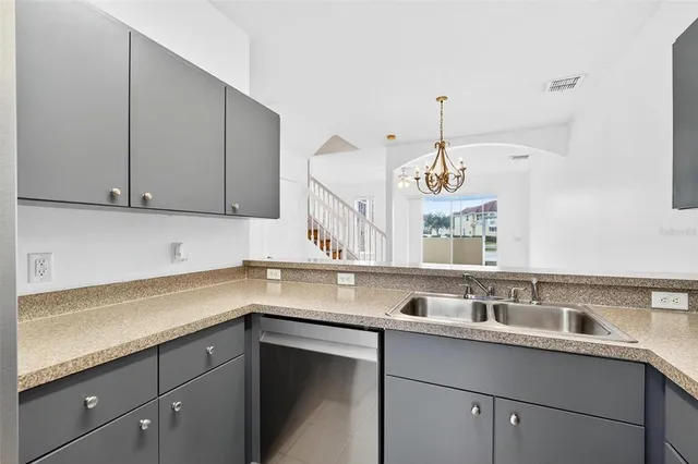 a view of an empty room with wooden floor and a ceiling fan