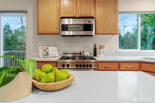 a kitchen with a stove a microwave a sink and cabinets