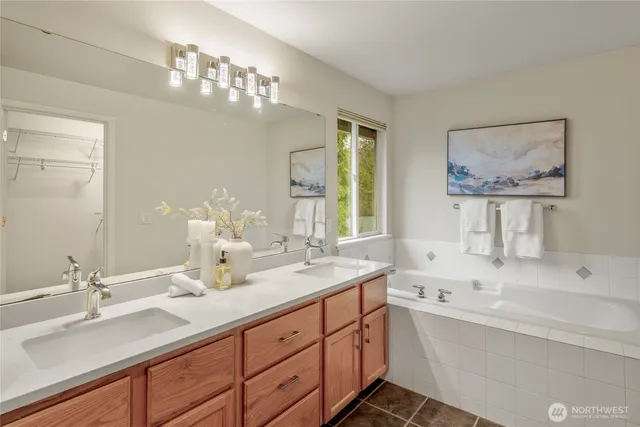 a bathroom with double vanity sinks a vanity and a large mirror